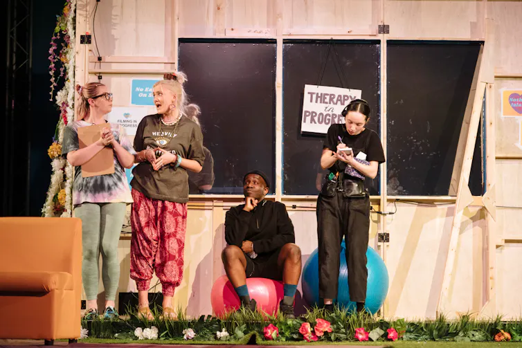 A group of contestants stand in the 'therapy' area of Nothing Island's set