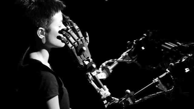 Un robot explore le visage d'un humain avec ses doigts