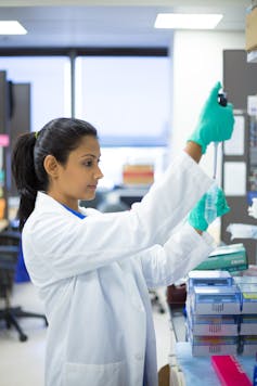 A woman in a white coat in a lab