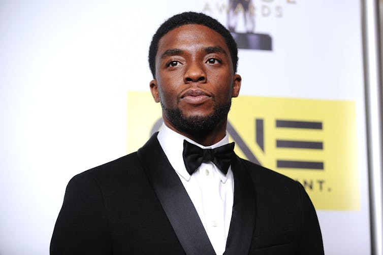 A photograph of a Black man wearing a tuxedo and bow tie.