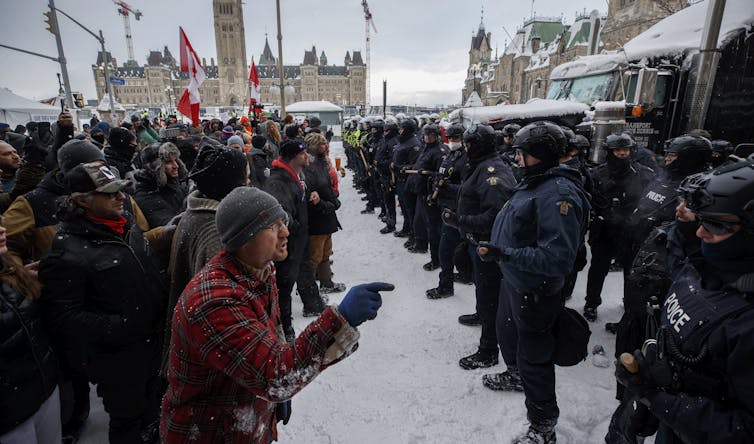 Los manifestantes de convoy se enfrentan a la policía frente al edificio del Parlamento canadiense.