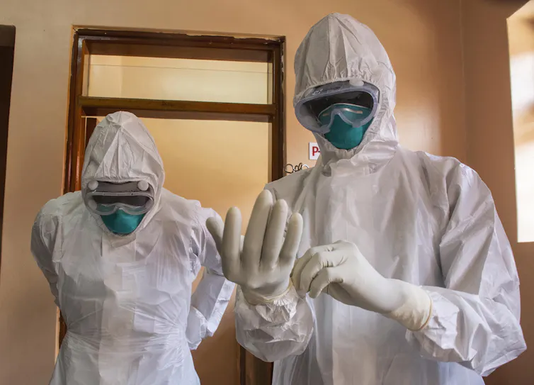 Two men in white HAZMAT suits.