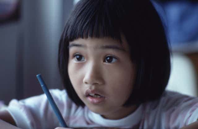 Primary student holding a pencil