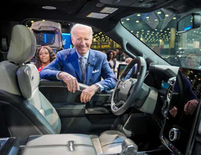 Joe Biden looking into a Cadillac Lyriq EV