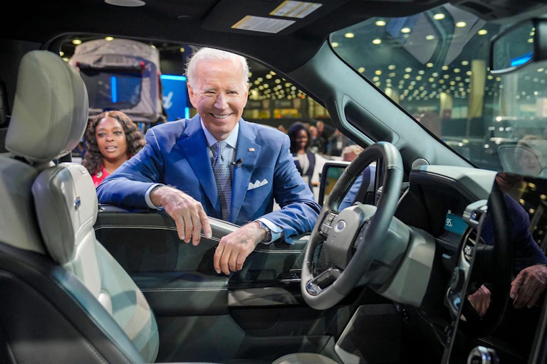 Joe Biden looking into a Cadillac Lyriq EV