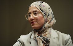 A woman wearing a hijab and glasses