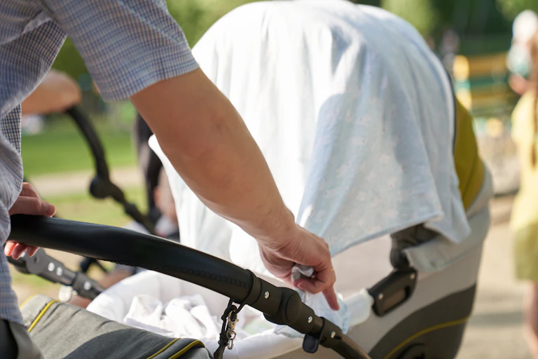 Person pulls a cloth over a pram