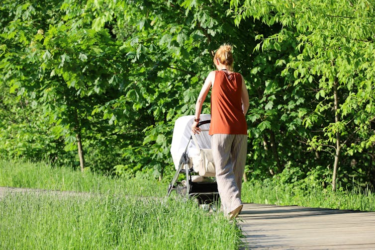 Woman pushes pram with muslin cloth