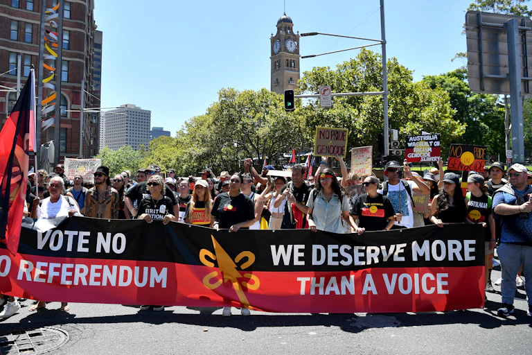 Protestors hold placards as they march through the CBD during an Invasion Day rally in Sydney.