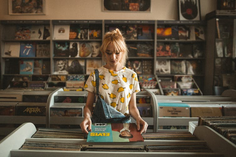 Teen girl in record store browsing