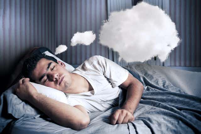 Hombre acostado durmiendo. Sobre él unas nubes representan sus sueños.
