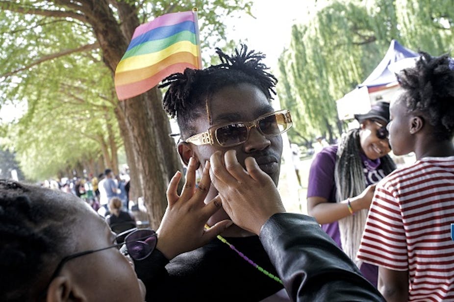 A rainbow flag is taped on the cheek of a member of the LGTBI community during the Soweto Pride in 2021.