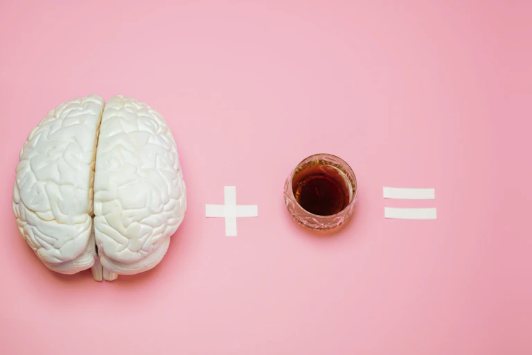 Ecuación con una figura con forma de cerebro, más un vaso con una bebida alcohólica y un signo de igual.