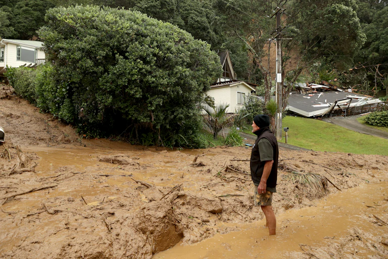 A resident inspecting a large landslide