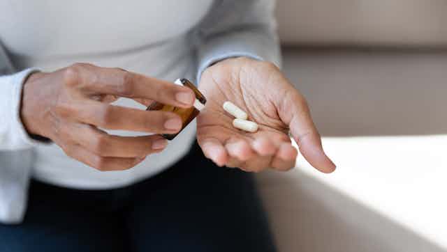 woman's hands hold two pills