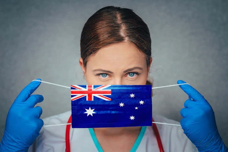 Doctor putting on a mask with the Australian flag printed on it