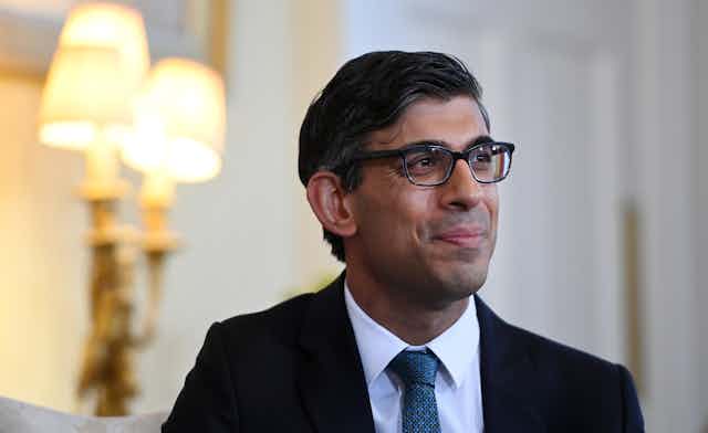 Close up of prime minister Rishi Sunak wearing glasses and looking resolved