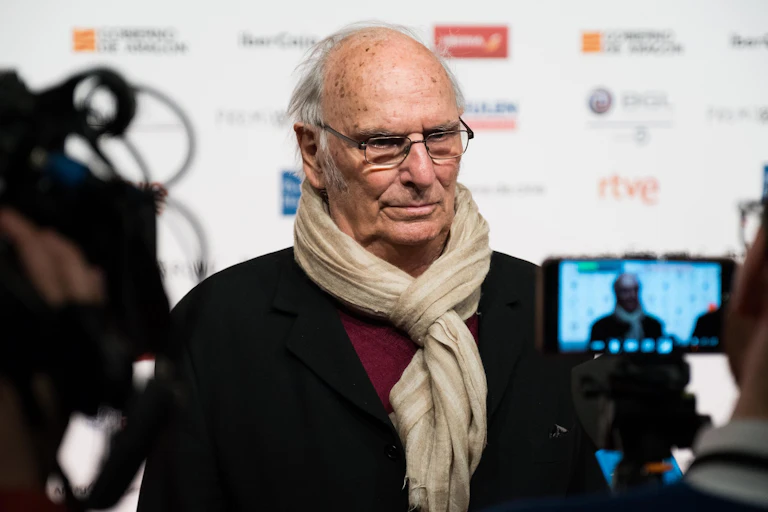 Un homme est interviewé sur un tapis rouge.