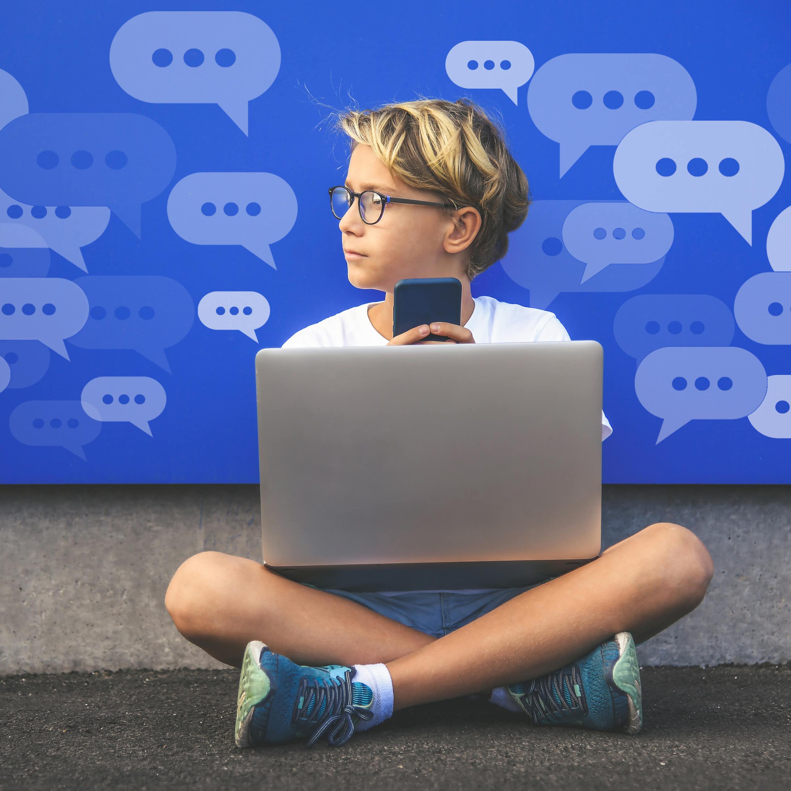 A boy with a laptop and holding a cell phone looks to the left. Conversation bubbles with dots are in the background.