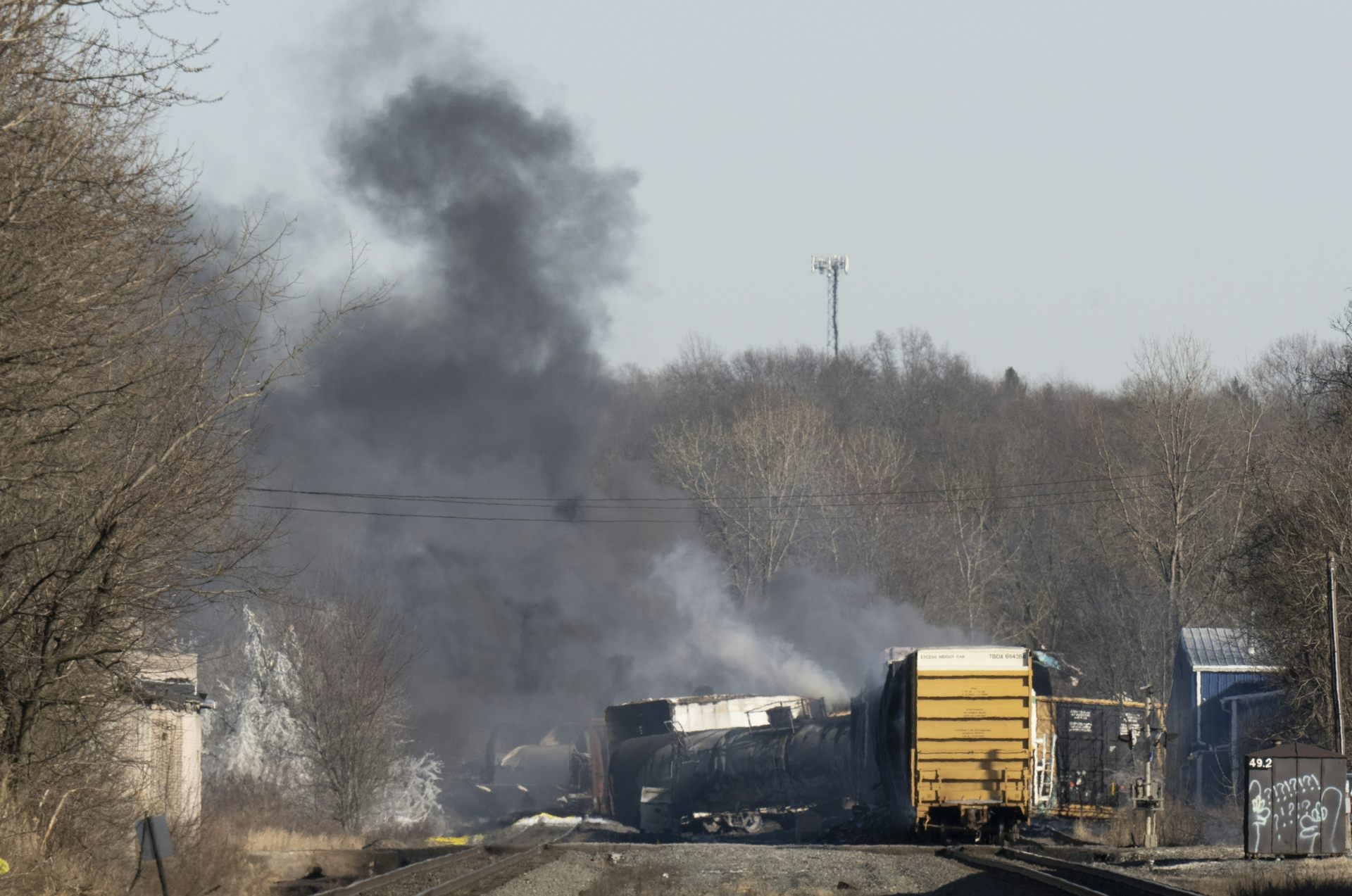 Photo de wagons du train déraillé dont s’élève un panache de fumée noire