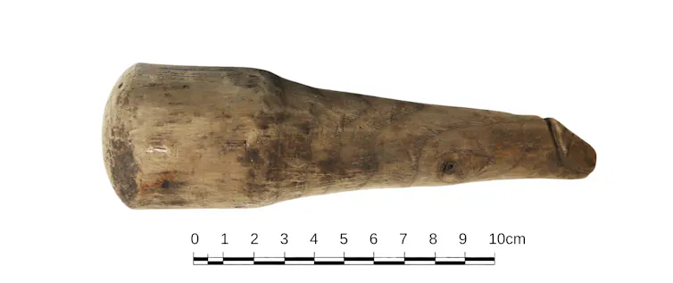 Une balance à côté du phallus en bois montre qu’il mesure 15 cm de long