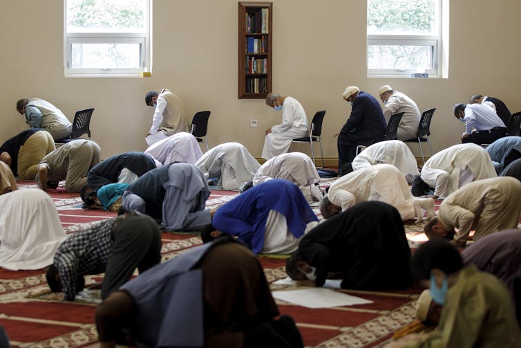 Men bow in prayer at a mosque.