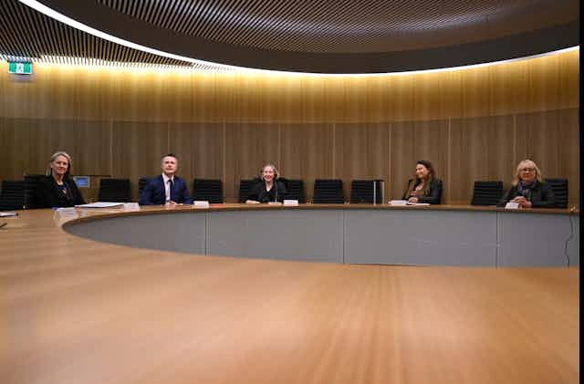 Members of the Universities Australia advisory group sitting at a conference table.