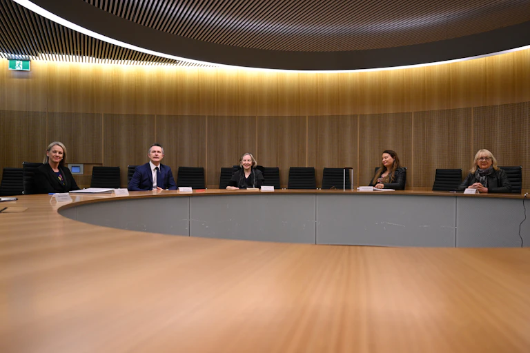 Members of the Universities Australia advisory group sitting at a conference table.