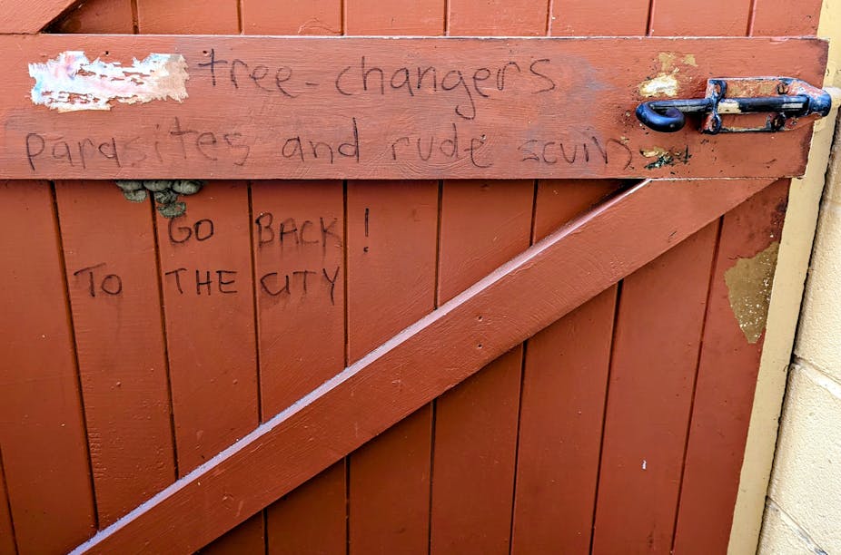 Message scrawled on gate to a property reads "Tree-changers are parasites and rude scum. Go back! To the city