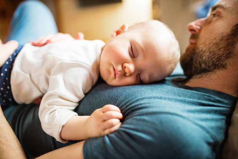 Baby sleeping on father's chest