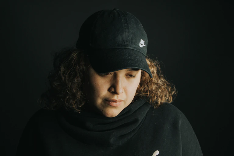 Woman in cap looks down