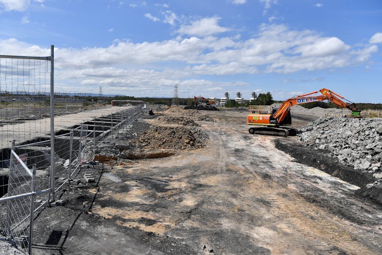 Waste ground with a digger and piles of rubble