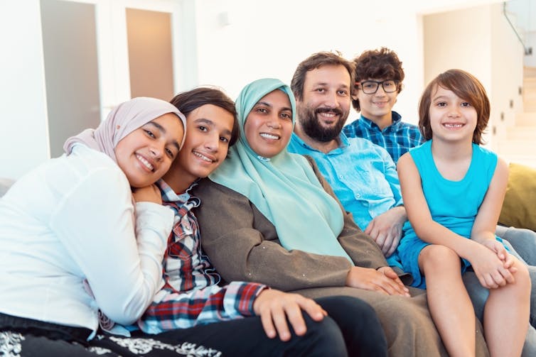 Family with 4 children sitting on sofa