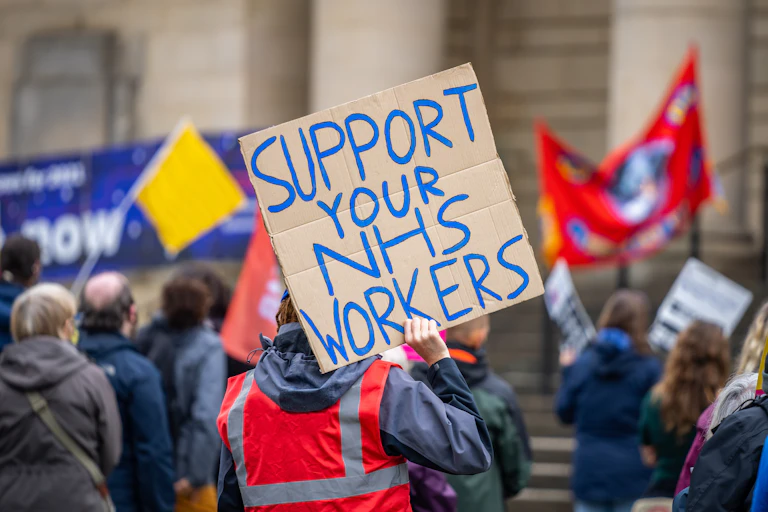People protest with banners in a city centre.