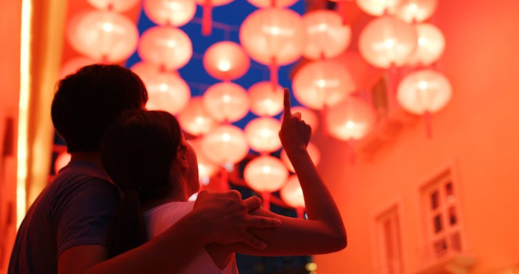 A Chinese couple points its finger to Chinese lanterns
