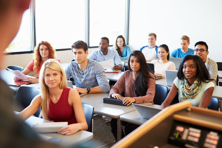 Students seen sitting with a teacher.