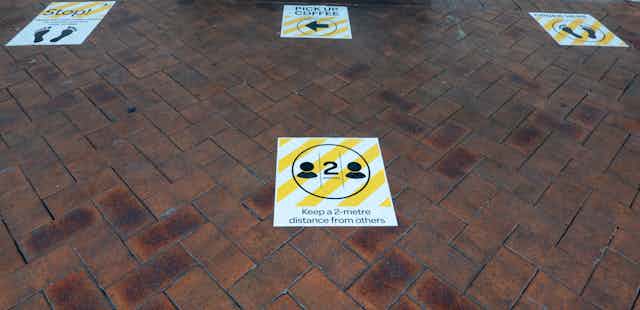 Two-metre social distancing pavement signs