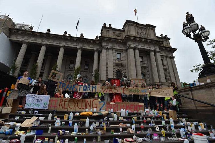 Protesters cover the steps of Parliament House in Melbourne with plastic and cardboard that should be recycled.