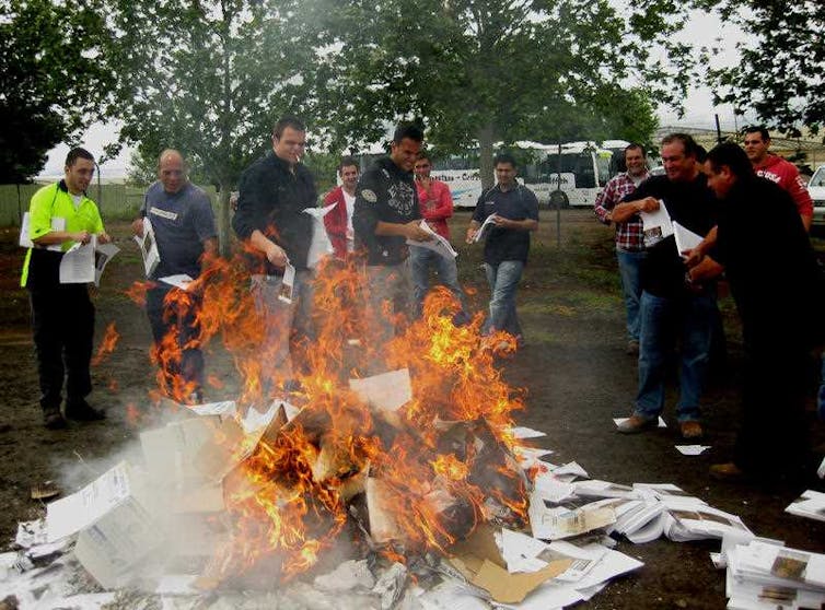 Young men burn copies of the guide to the Murray-Darling Basin Plan on a bonfire in the carpark outside the Murray-Darling Basin Authority meeting in Griffith, NSW, Thursday, Oct. 14, 2010.