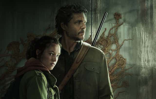 A girl and a man with a rifle stand in front of a cement wall with tendrils growing on it