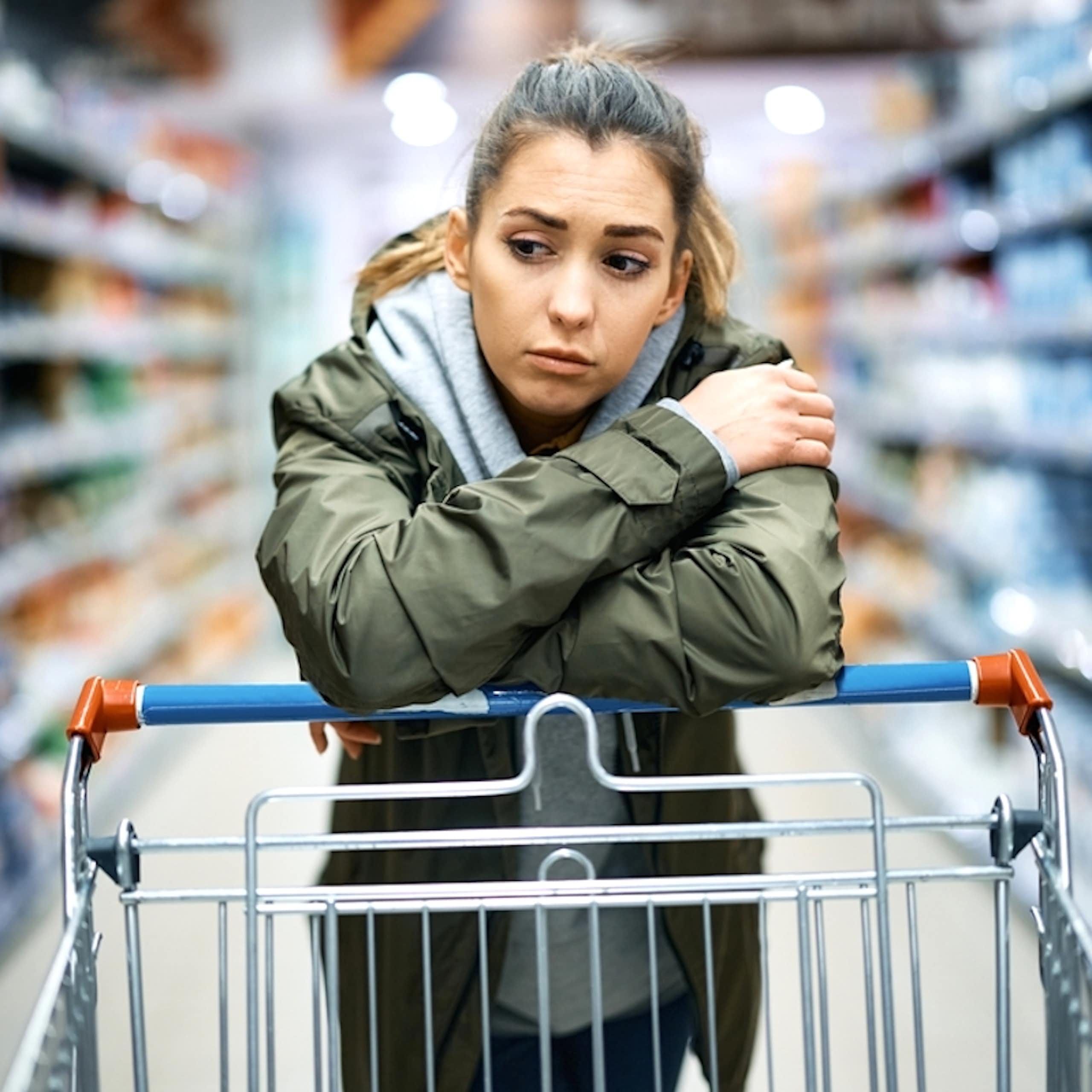 Jeune femme sceptique dans un rayon de supermarché.