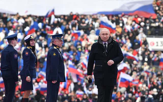 Putin leaves the stage after addressing a crowd of sjupporters