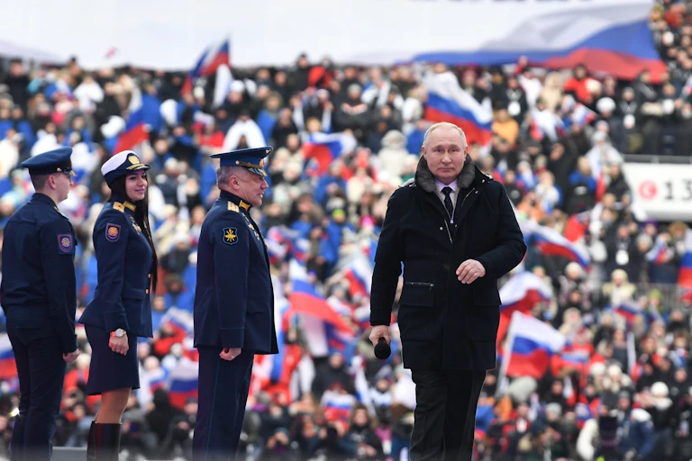 Putin leaves the stage after addressing a crowd of sjupporters