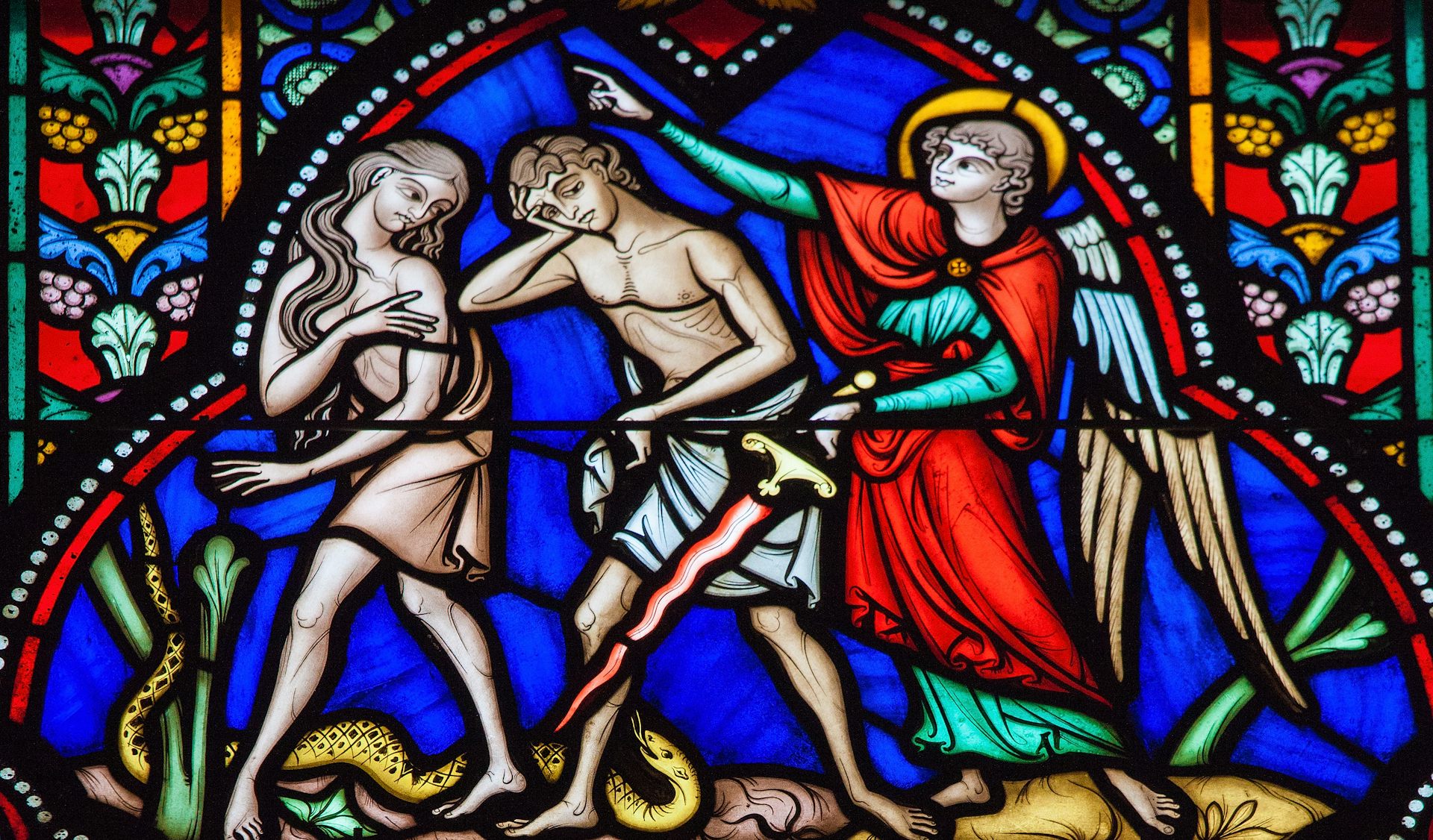 A stained glass window depicting Adam and Eve.