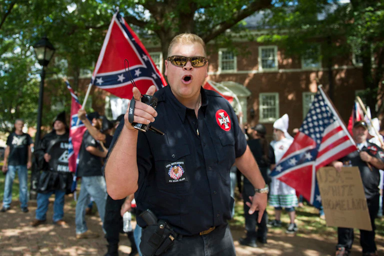 White man in military garb yelling at anti-racism protestors.