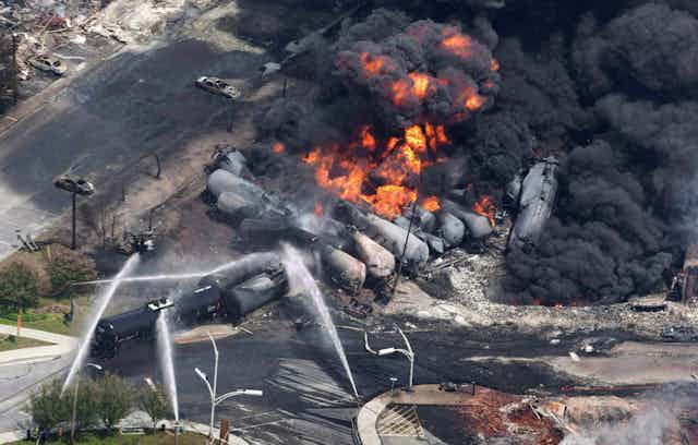 Several burned out rail cars are being sprayed with water in this aerial photograph of the crash site