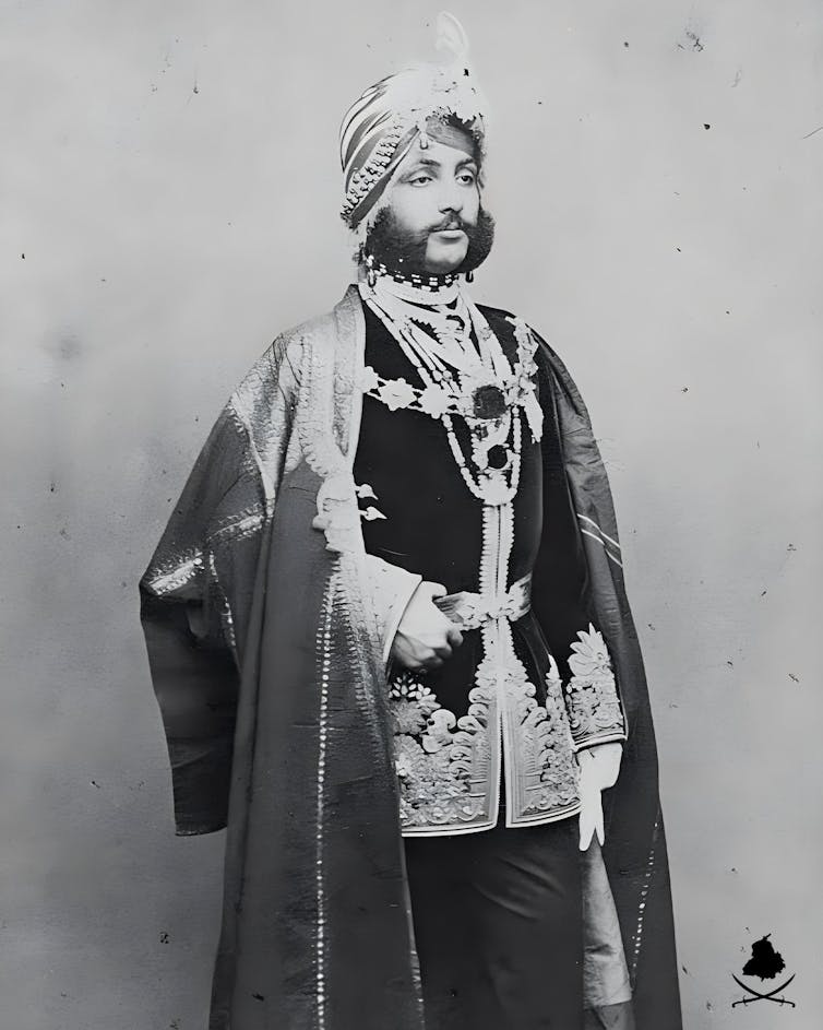 A black and white photograph of a man in ceremonial attire.