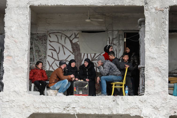People dressed for winter gather in a semi-outdoor space.