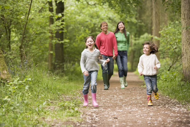 A family walking down a path in the woods.