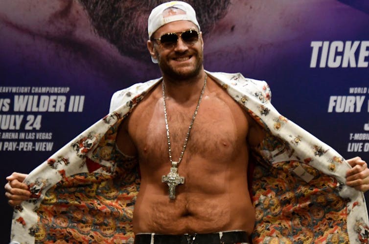 Man with sunglasses wearing a religious cross as a medallion